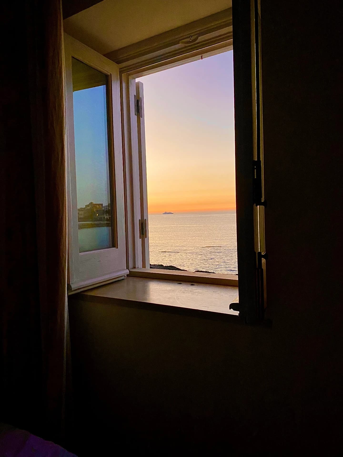 Window overlooking the sea at sunset