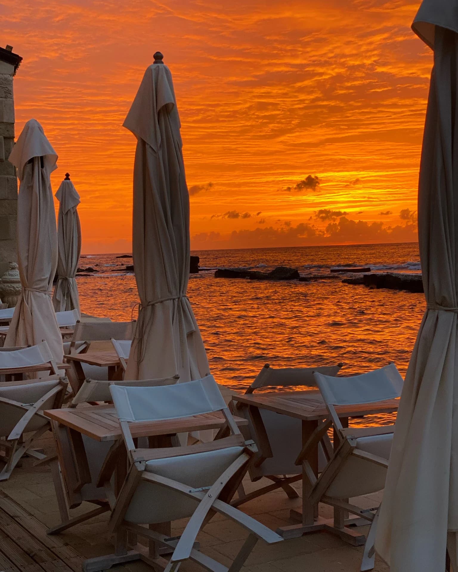 Beach at sunset with sunbeds and umbrellas