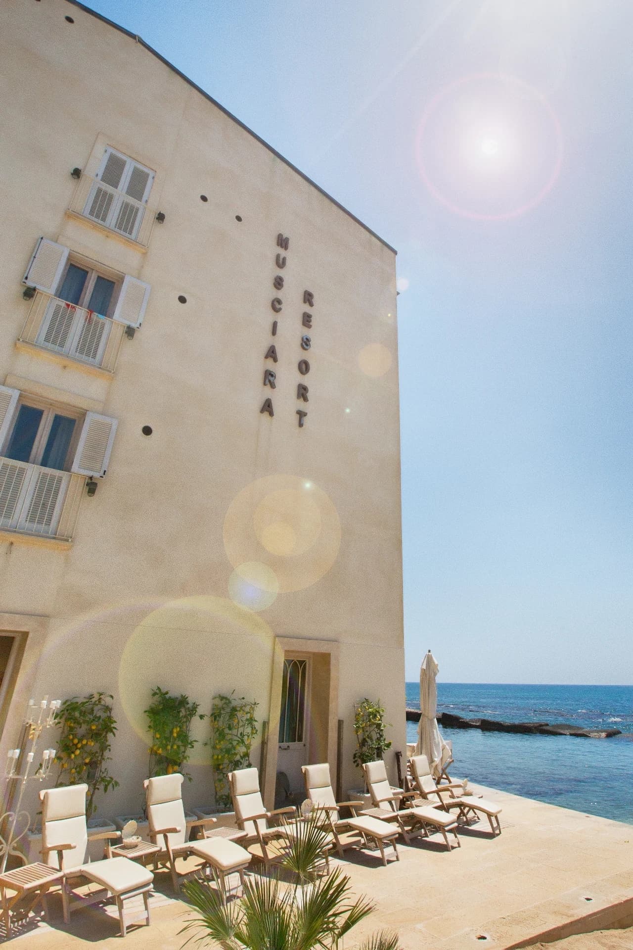 Resort façade with sunbeds by the sea
