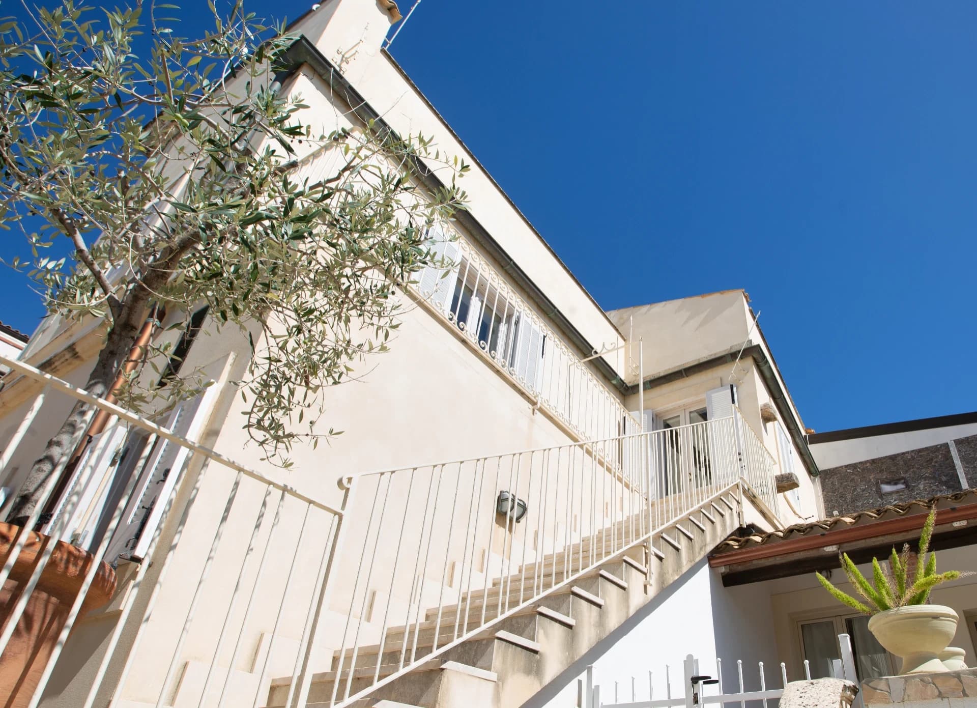 External staircase with olive tree and blue sky