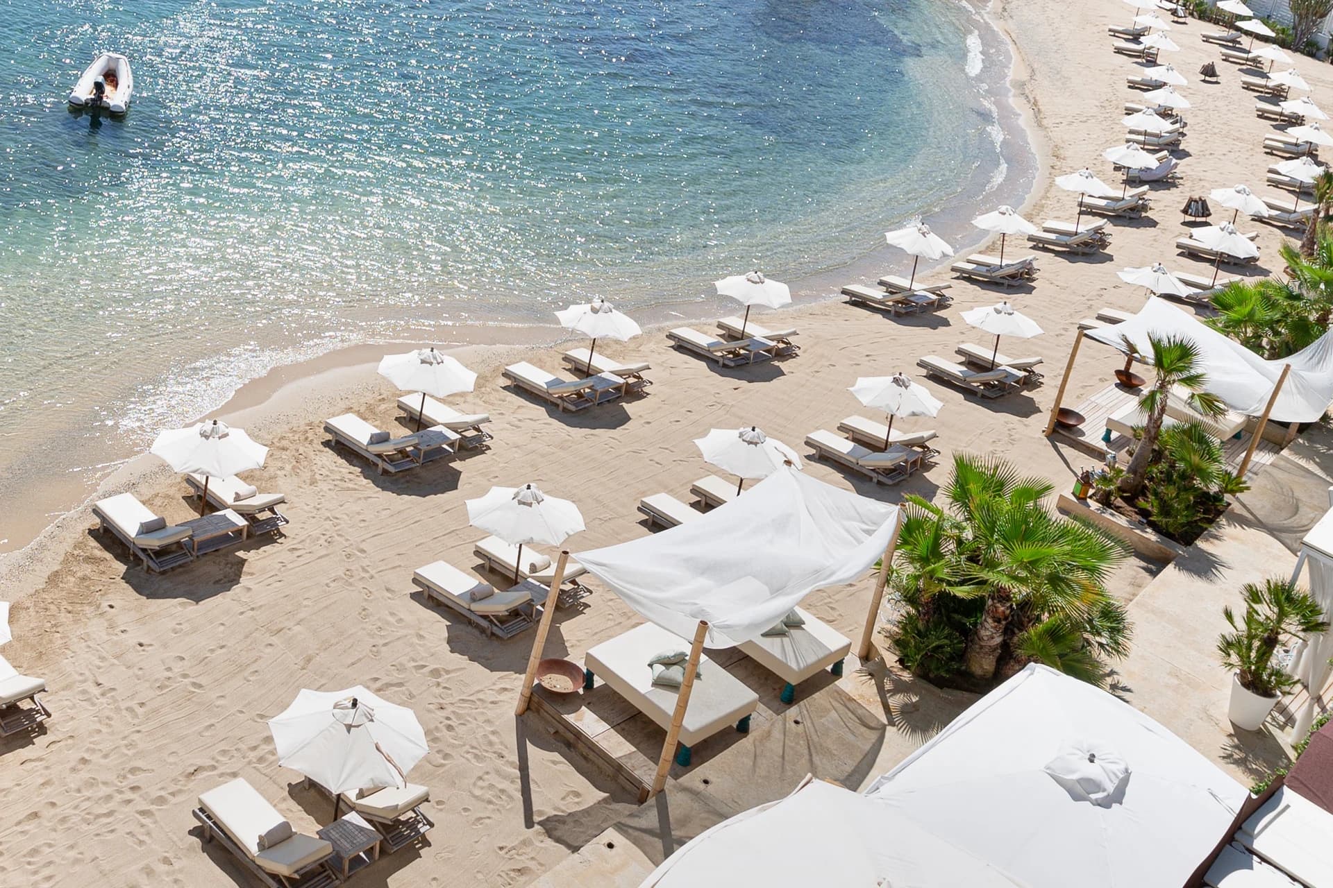 Bay with white sunbeds and umbrellas