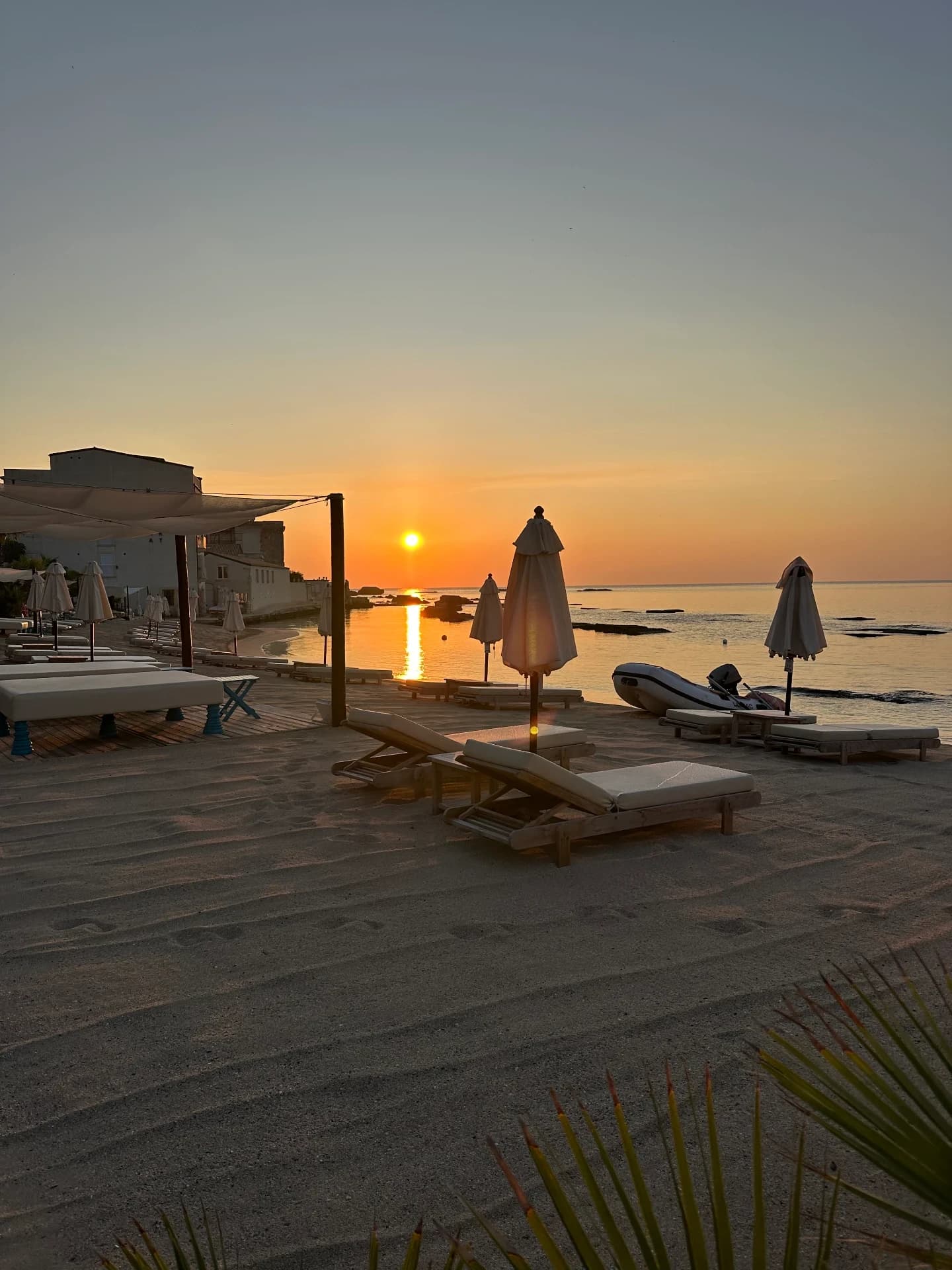 Sunset over the beach with sunbeds