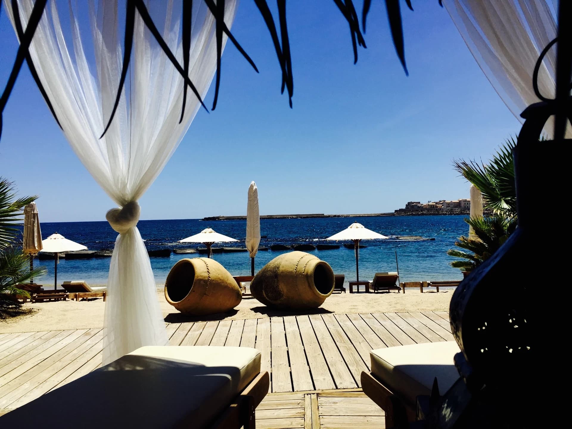 Cabana with white curtains overlooking the sea